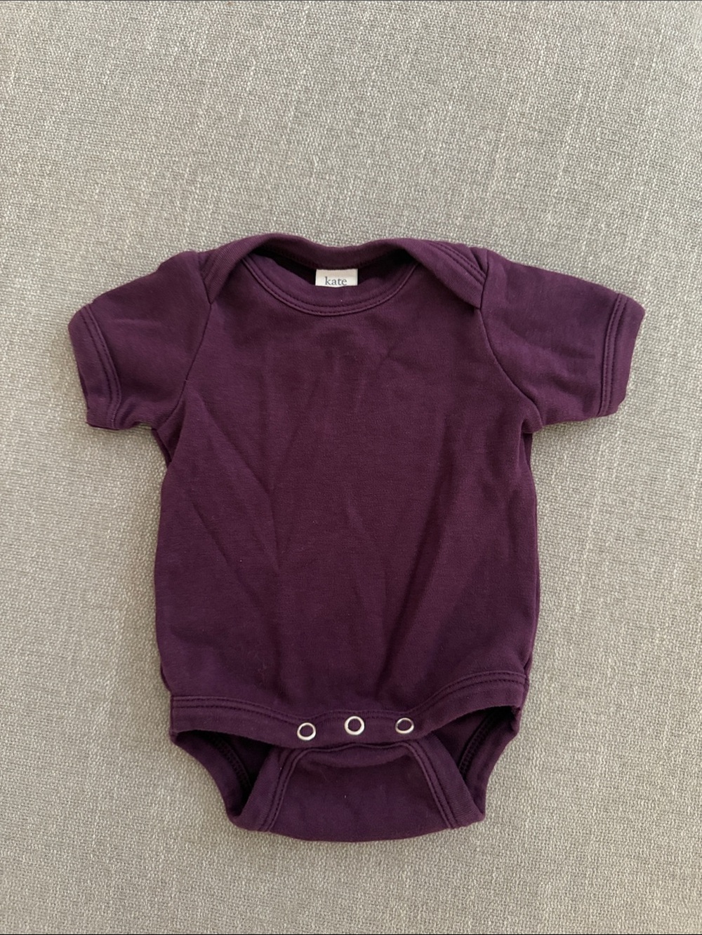 Kate Quinn Plum Short-Sleeve Baby One-Piece. Size NB